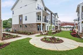 Landscaped courtyard with walking paths and flower beds at The Courts at Maverick Yards Apartments, Mauldin