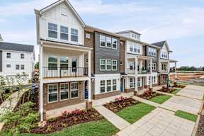 Row of townhomes with front patios and landscaping at The Courts at Maverick Yards Apartments, Mauldin, SC 29662