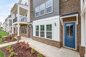 Brick townhome entrance with blue door and window boxes at The Courts at Maverick Yards Apartments, Mauldin, SC