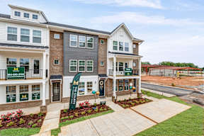 Townhome models with landscaping and welcome banners at The Courts at Maverick Yards Apartments, Mauldin, 29662