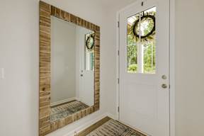 Entryway with wooden framed mirror and wreath at The Courts at Maverick Yards Apartments, South Carolina