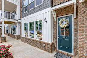 Brick townhome entrance with blue door and wreath at The Courts at Maverick Yards Apartments, South Carolina, 29662