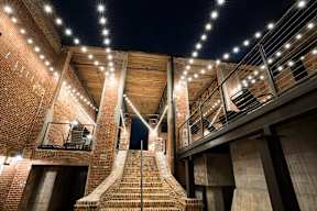Cotton Mill Apartments exterior, open-walled community patio with stringlights and stairs