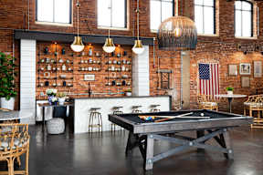 Cotton Mill Apartments pool table in the cubhouse, with brick walls and a kitchen island with stools