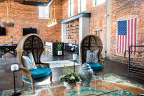 Cotton Mill Apartments clubhouse with two chairs, brick walls and a pool table.
