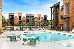 Cotton Mill Apartments pool with tables and lounge chairs
