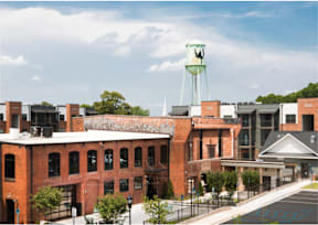 Cotton Mill Apartments exterior with water tower in background
