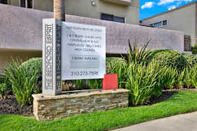 A sign for The Bedford Esprit apartment complex lists the amenities.