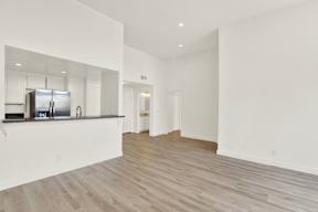 A spacious kitchen with white cabinets and a refrigerator.