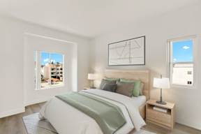 A bedroom with a large bed and a window overlooking a cityscape.