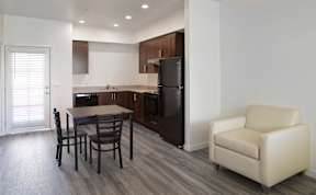 A kitchen with a table and chairs.