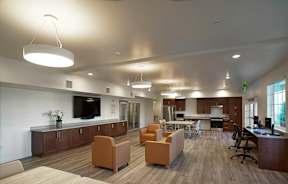A modern office space with a kitchen area and seating.