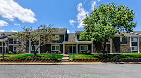 Exterior of a building at Somerset Lakes Apartments, showcasing a well-maintained facade and beautiful landscaping.