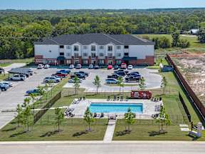 A large white building with a pool in front.