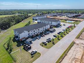 A large white building with a parking lot in front of it.