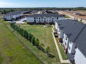 A large apartment complex with multiple buildings and green lawns.