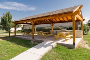 a pavilion with picnic tables on a concrete patio