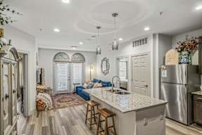 A kitchen with a large island and a refrigerator.