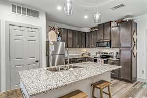 A kitchen with a granite countertop and stainless steel appliances.