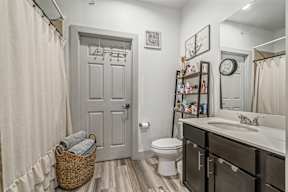 A bathroom with a white toilet, a white sink, and a white door.