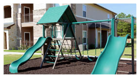 a playground with two slides at Cypress Creek Apartment