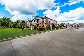 Exterior view of Timber Creek Apartments in Sulphur Springs, TX with landscaped grounds