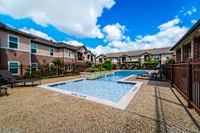 Outdoor swimming pool and sundeck at Timber Creek Apartments in Sulphur Springs, TX