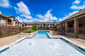 Outdoor swimming pool and sundeck at Timber Creek Apartments in Sulphur Springs, TX