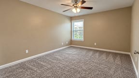 A room with a ceiling fan and a window.