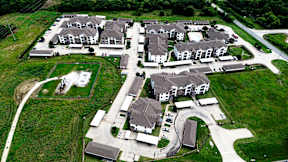 A bird's eye view of a housing development with multiple houses and a central courtyard.