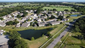 an aerial view of a neighborhood with a body of water in the middle