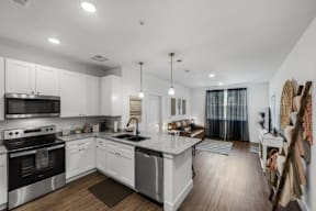 A modern kitchen with white cabinets and stainless steel appliances at Flat Creek Apartments in Athens TX.