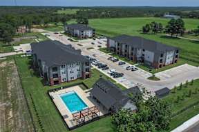 An aerial view of a resort with a swimming pool.