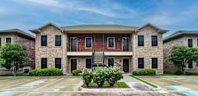 A large brick house with a balcony on the second floor.