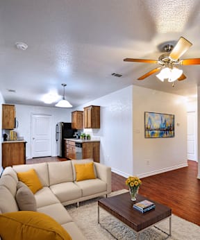 A living room with a white couch and a ceiling fan.