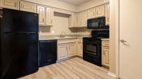 a kitchen with white cabinets and black appliances