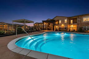 A swimming pool in a residential area at dusk.