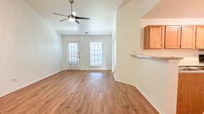 A room with wooden flooring and a ceiling fan.