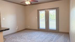 Spacious apartment living room with patio access at Timber Creek Apartments
