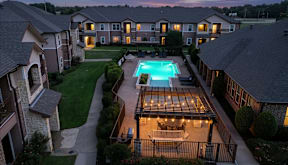 Evening view of the swimming pool and apartment community at Timber Creek Apartments