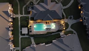 Aerial evening view of the pool and apartment homes at Timber Creek Apartments in Sulphur Springs, TX
