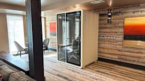 A room with a wooden wall and a glass door.