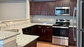 A kitchen with brown cabinets and stainless steel appliances.