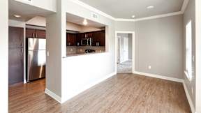 A kitchen with wooden floors and a refrigerator.