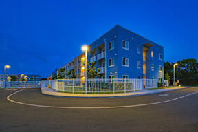 A blue building with a white fence and a roundabout in front.