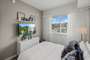 A bedroom with a large bed and a television on a stand.