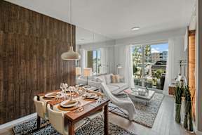 A modern dining room with a wooden table and chairs.