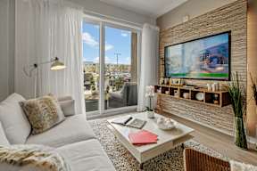A modern living room with a flat screen TV mounted on the wall.