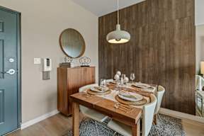 A dining room with a wooden table set for two.