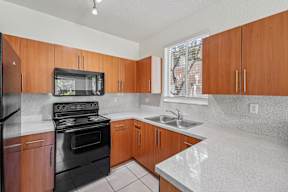 A kitchen with wooden cabinets and black appliances.